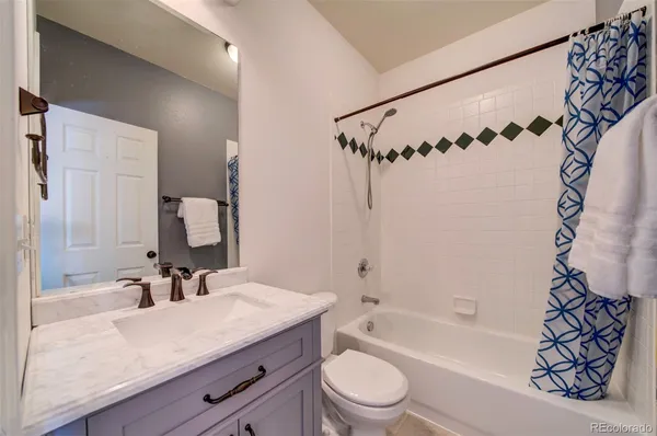 a bathroom with a granite countertop sink a mirror a vanity and bathtub