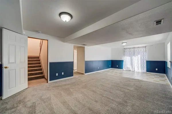 a view of an empty room with a fireplace and a window