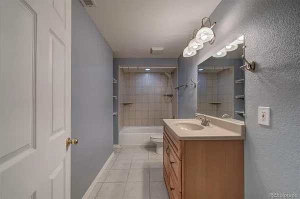 a bathroom with a sink a toilet a mirror and shower