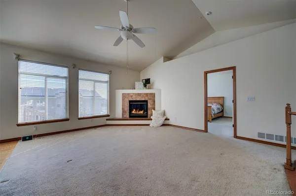 a view of an empty room with a fireplace and a window