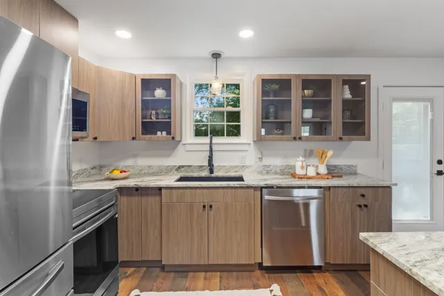 a kitchen with granite countertop a sink stove and cabinets