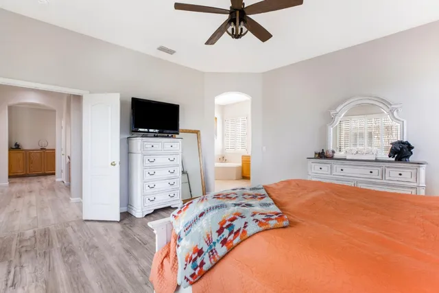 a bedroom with a bed and a television on the dresser