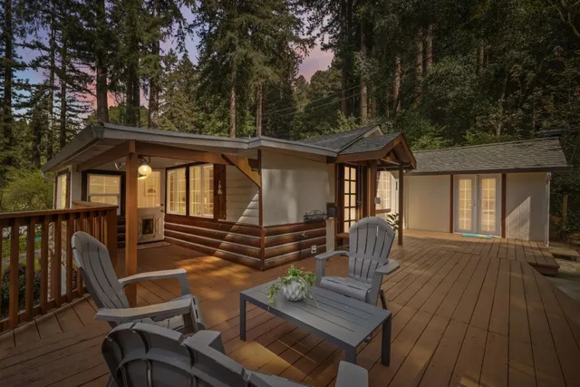 a view of a patio with table and chairs with wooden floor and fence