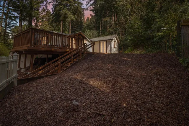 a front view of house with yard and trees in the background