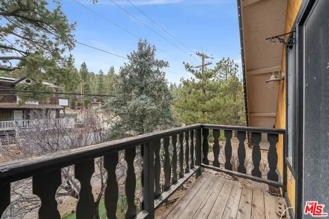 a view of a balcony with wooden floor and fence