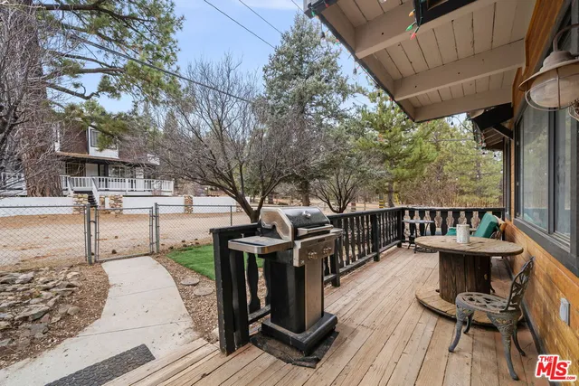 a view of a patio with table and chairs with wooden floor and fence
