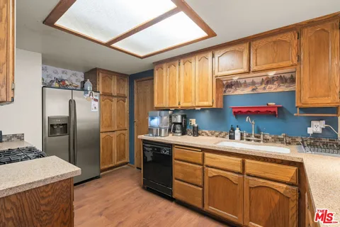 a kitchen with stainless steel appliances a sink cabinets and a refrigerator