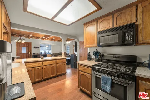 a kitchen with stainless steel appliances granite countertop a stove a sink and a microwave