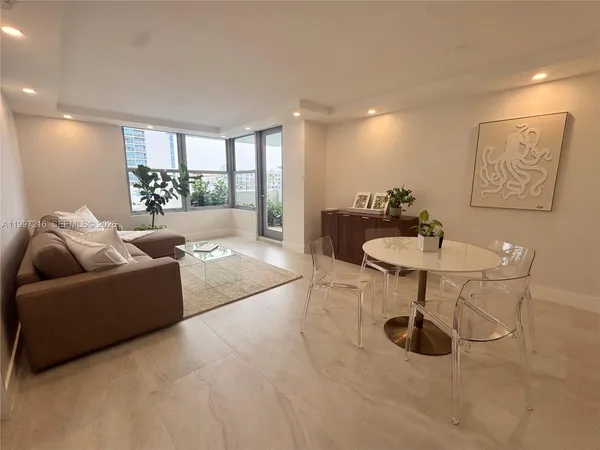 a living room with furniture a lamp and a potted plant