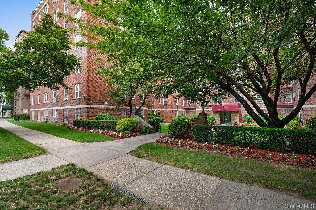 485 Bronx River Road, Unit A21 Yonkers, NY 10704 - Photo 17 of 18 a front view of a house with a yard and a garden