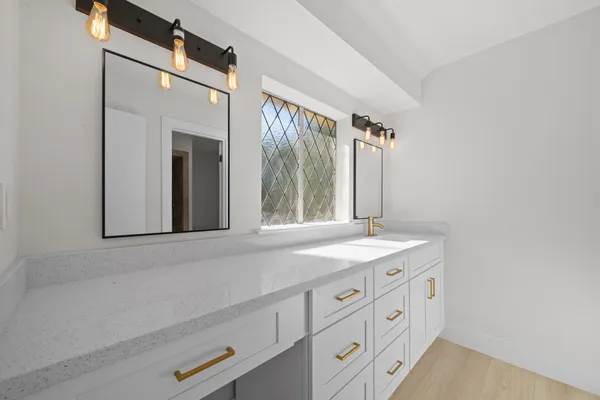 a bathroom with a granite countertop sink a toilet and a mirror