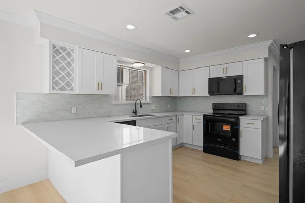 a kitchen with a refrigerator and a stove top oven