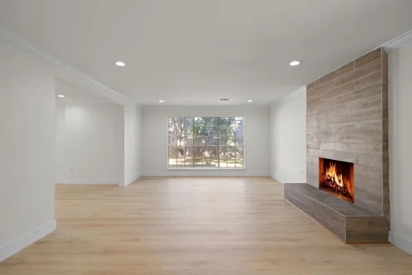 a view of an empty room with a fireplace and a window