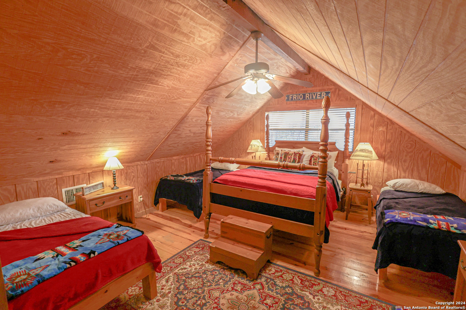 1177 River Road Concan, TX 78838 - Photo 22 of 34 a bedroom with a bed and a lamp on the wall