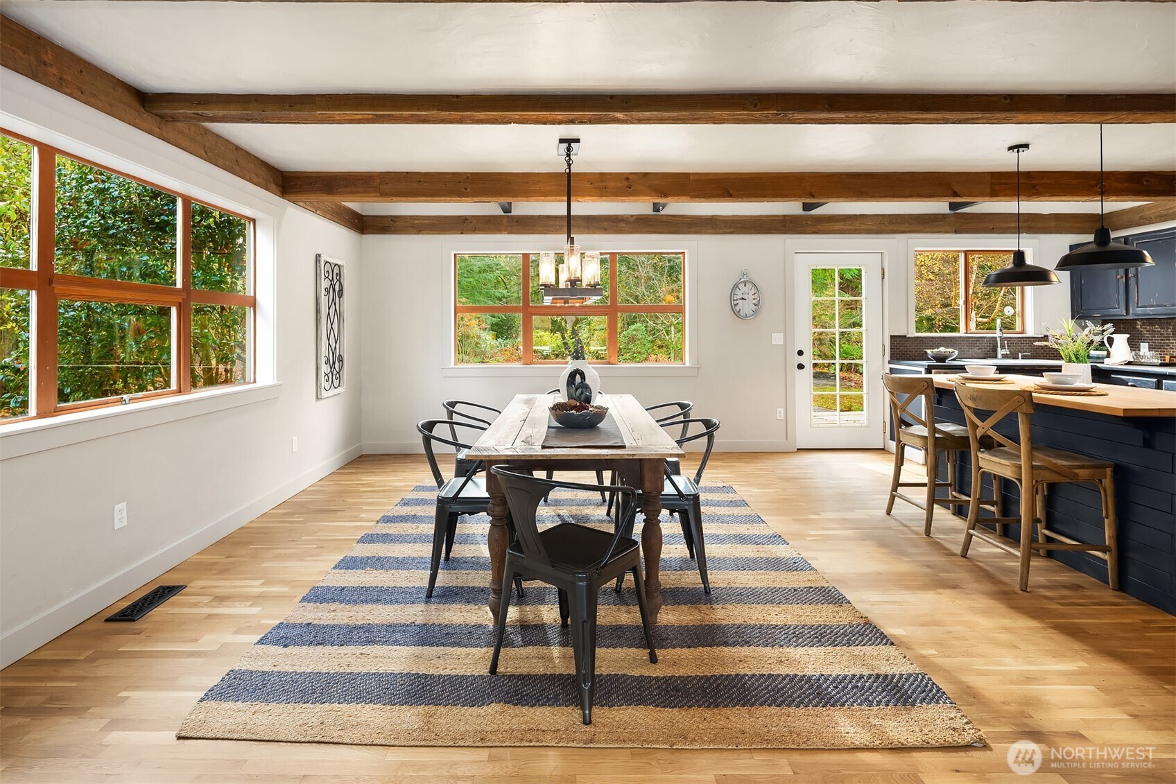 41715 Southeast 101st Street North Bend, WA 98045 - Photo 7 of 38 a dining room with wooden floor a chandelier a glass table and chairs