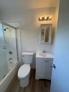 a bathroom with a toilet a sink a tub and mirror