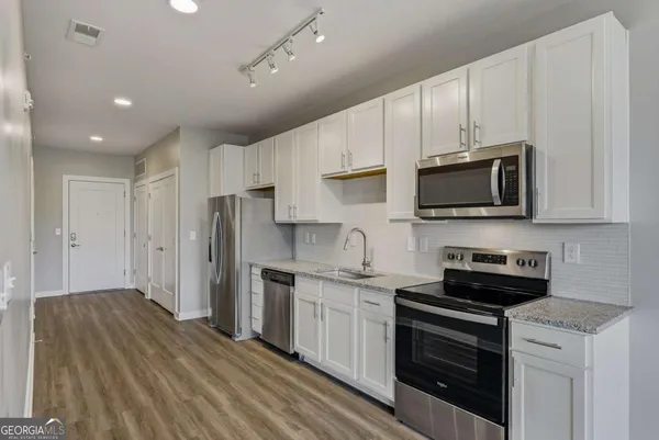 a kitchen with stainless steel appliances a stove sink microwave and cabinets