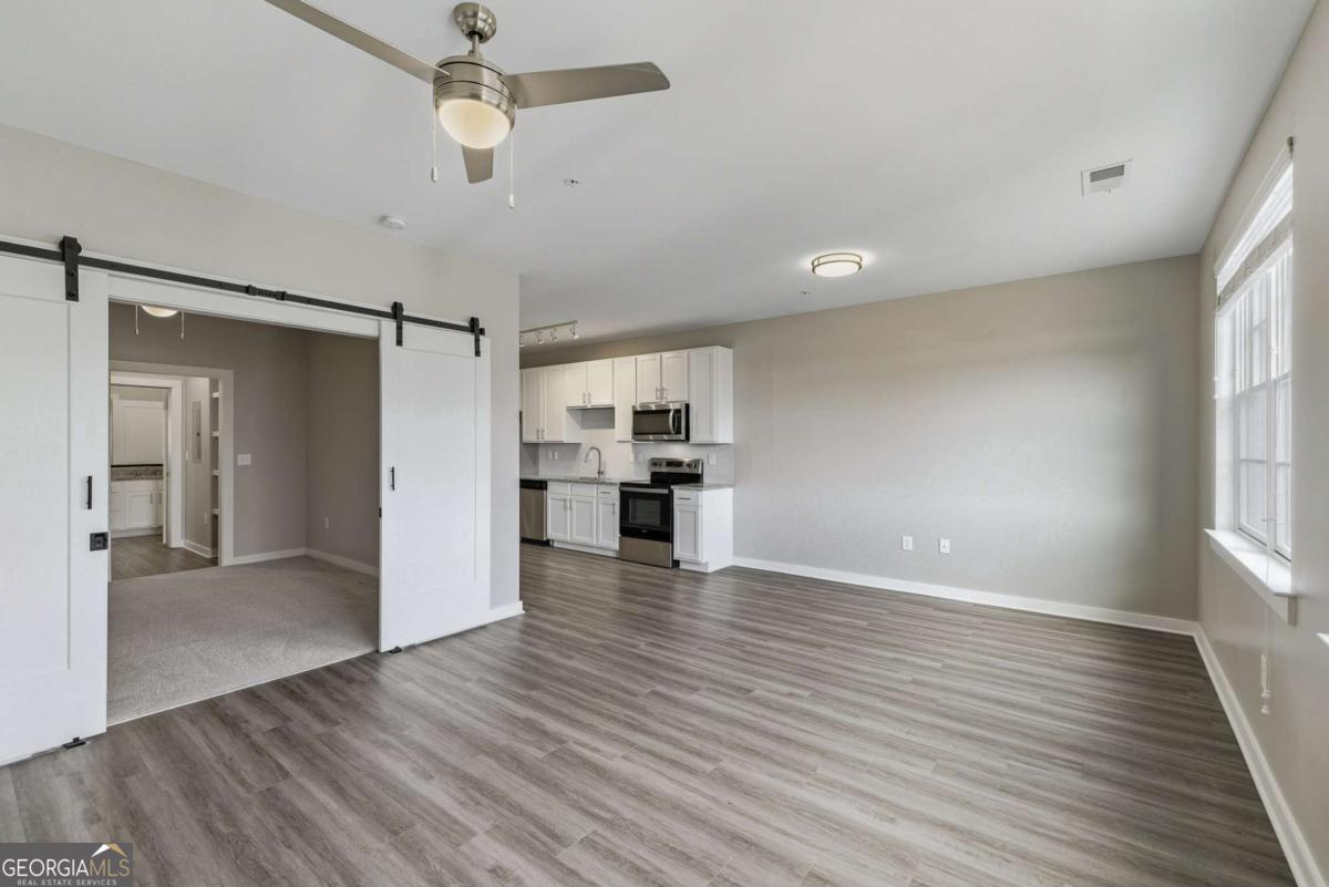 100 Prince Avenue, Unit A404 Athens, GA 30601 - Photo 14 of 27 wooden floor in an empty room with a kitchen