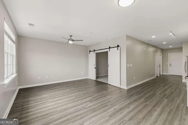 an empty room with wooden floor and windows