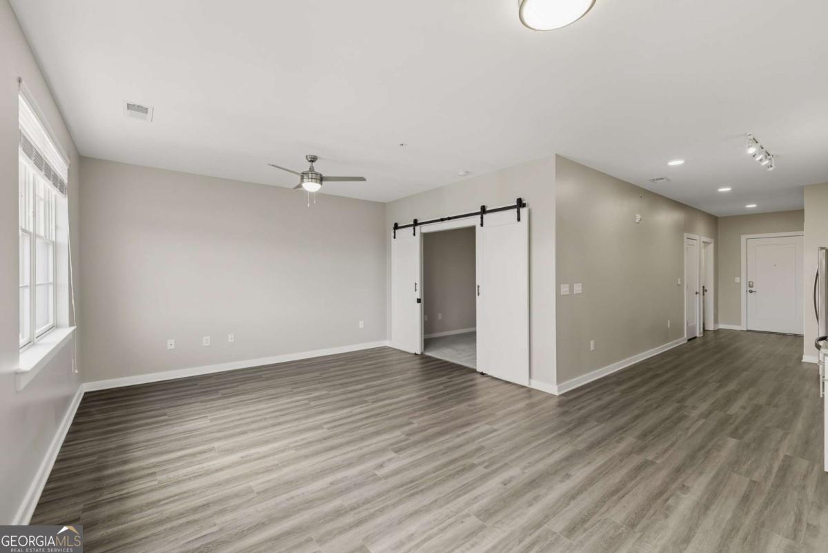 100 Prince Avenue, Unit A404 Athens, GA 30601 - Photo 15 of 27 an empty room with wooden floor and windows