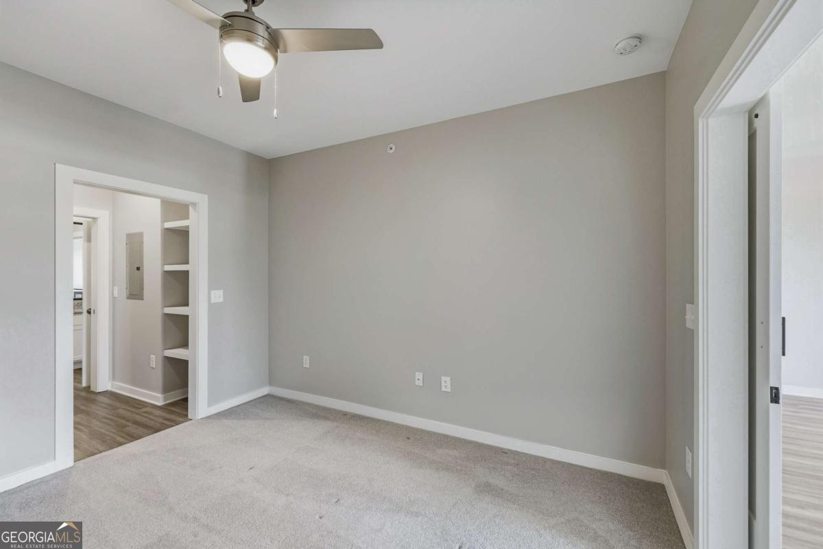 100 Prince Avenue, Unit A404 Athens, GA 30601 - Photo 18 of 27 an empty room with a empty space and a ceiling fan