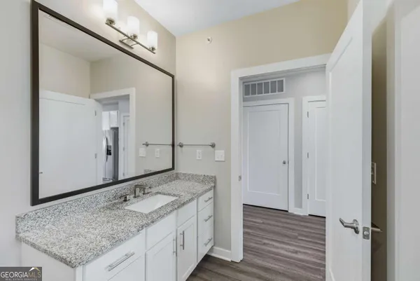 a bathroom with a granite countertop sink and a mirror