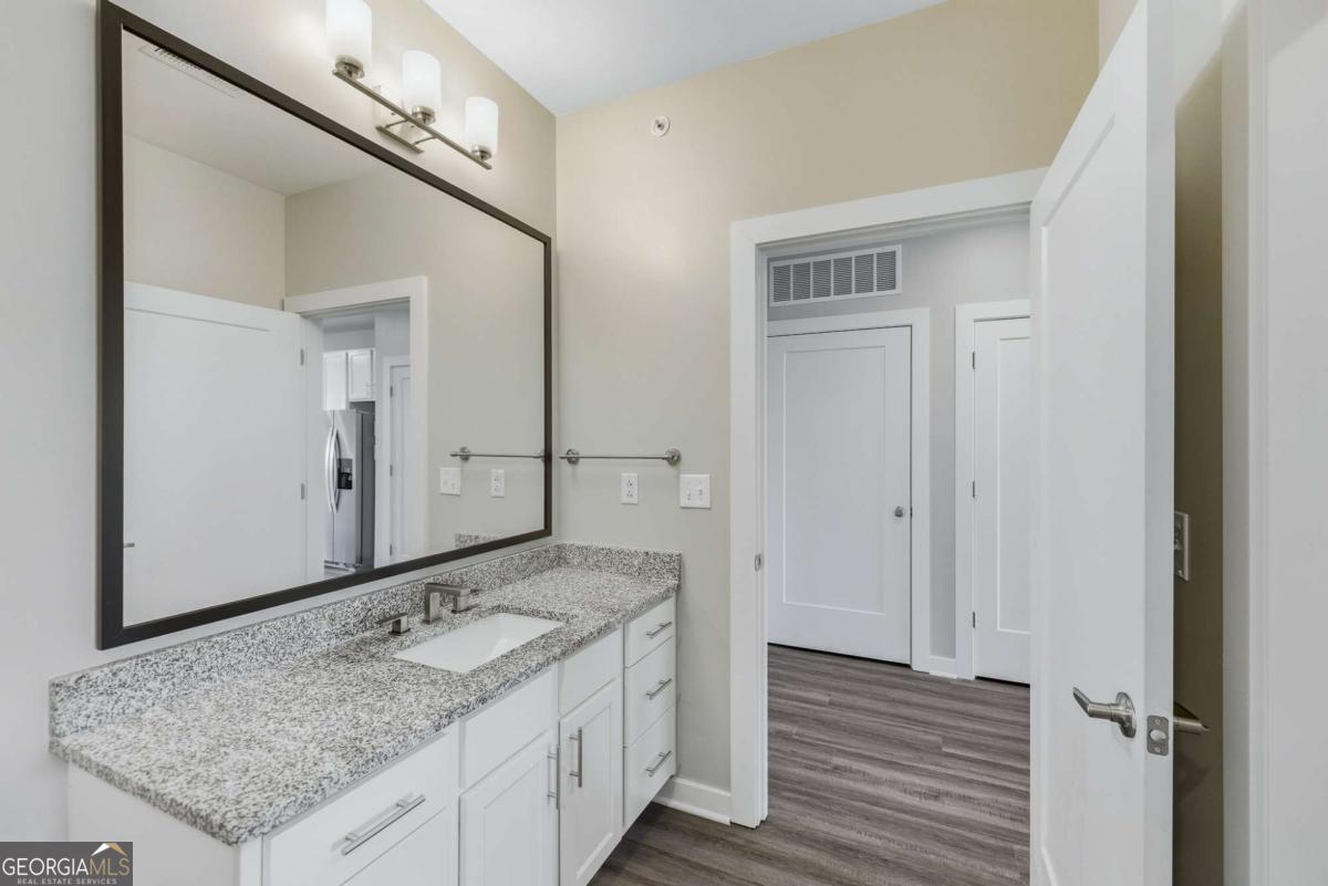 100 Prince Avenue, Unit A404 Athens, GA 30601 - Photo 20 of 27 a bathroom with a granite countertop sink and a mirror
