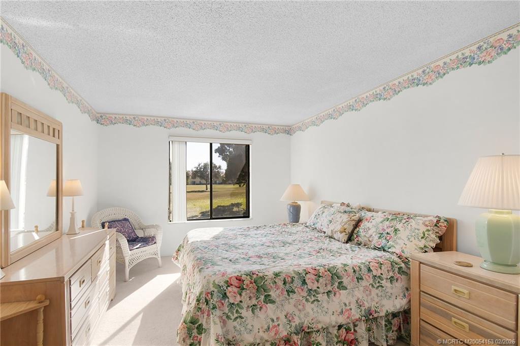5413 Southeast Miles Grant Road, Unit G206 Stuart, FL 34997 - Photo 15 of 79 a bedroom with a large bed and a large window
