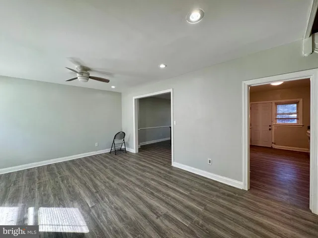 a view of a room with wooden floor and a ceiling fan