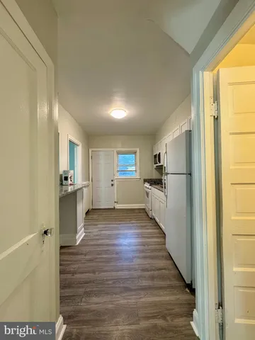 a view of a refrigerator in kitchen and wooden floor