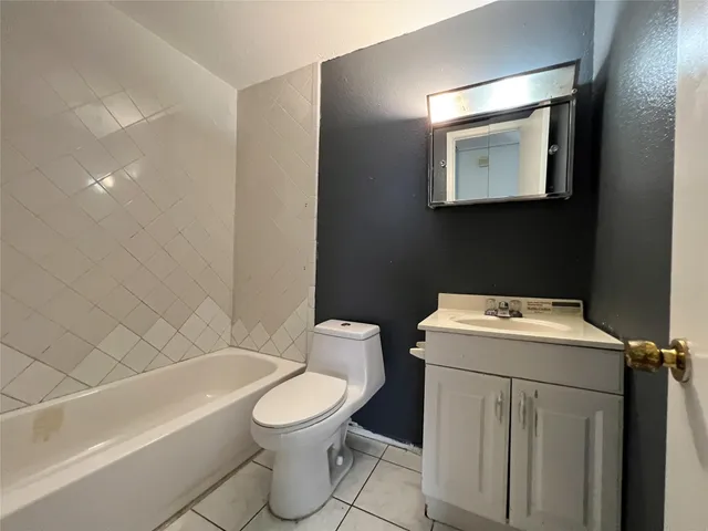 a white toilet sitting next to a bath tub