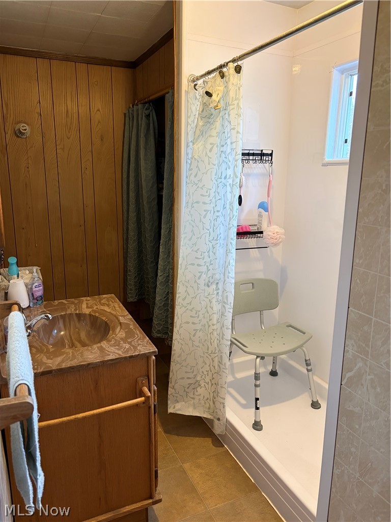 3719 Holmes Road Cambridge, OH 43725 - Photo 14 of 20 Bathroom featuring vanity, a shower with curtain, and wooden walls