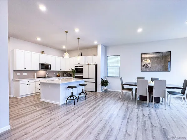 a kitchen with a table chairs refrigerator and cabinets