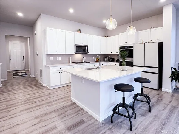a large kitchen with kitchen island a sink table and chairs