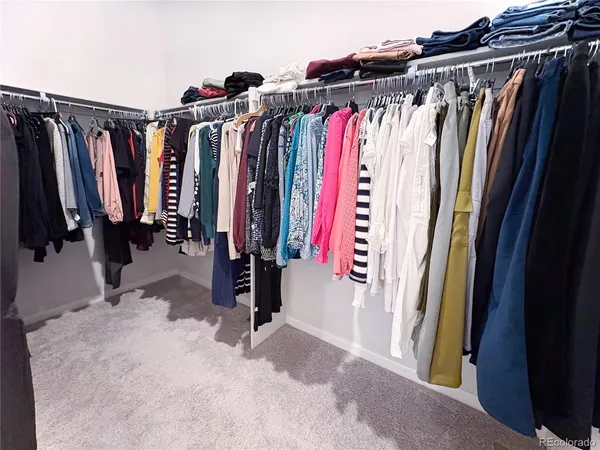 a view of walk in closet with clothes