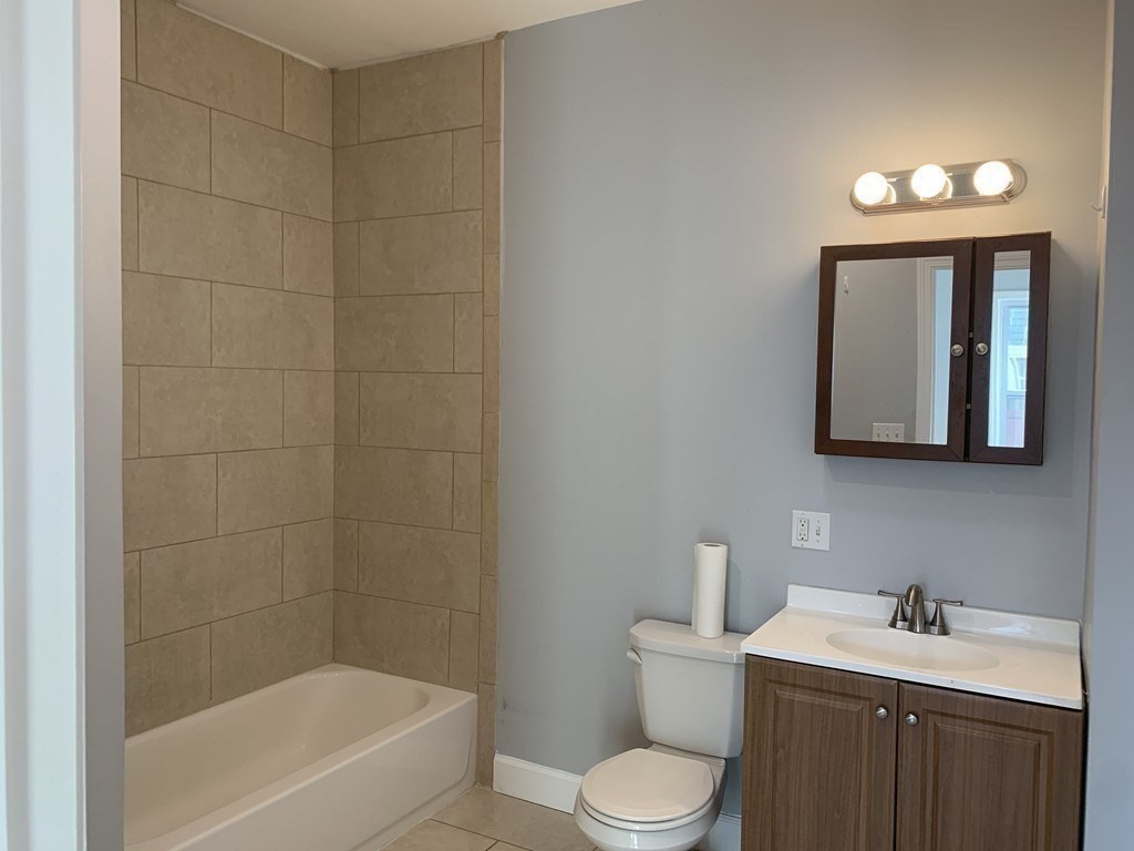 107 Chelsea Street, Unit 3 Boston, MA 02128 - Photo 11 of 15 a bathroom with a toilet a sink a mirror and bathtub