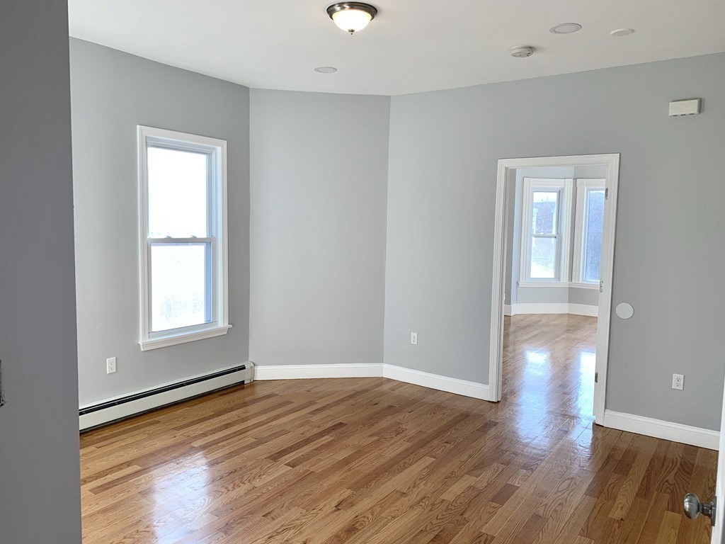 107 Chelsea Street, Unit 3 Boston, MA 02128 - Photo 5 of 15 a view of empty room with wooden floor and fan