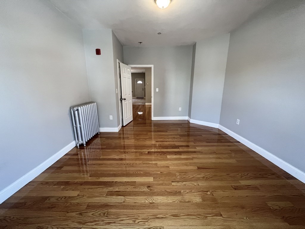 107 Chelsea Street, Unit 3 Boston, MA 02128 - Photo 6 of 15 a view of an empty room with wooden floor and a window
