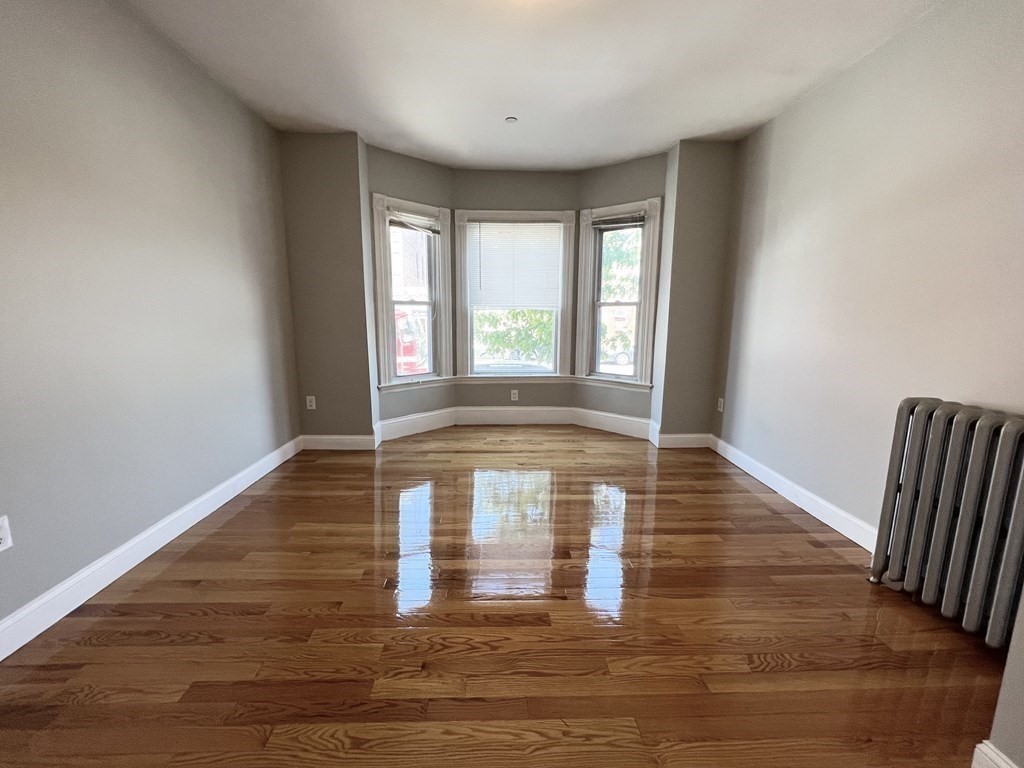 107 Chelsea Street, Unit 3 Boston, MA 02128 - Photo 7 of 15 a view of an empty room with wooden floor and a window