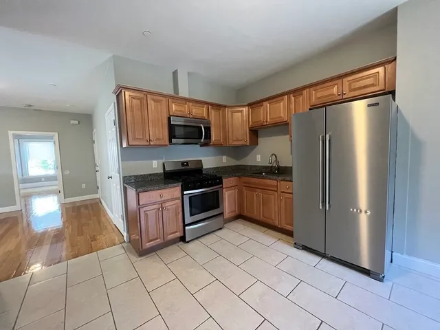a kitchen with stainless steel appliances a refrigerator sink and microwave