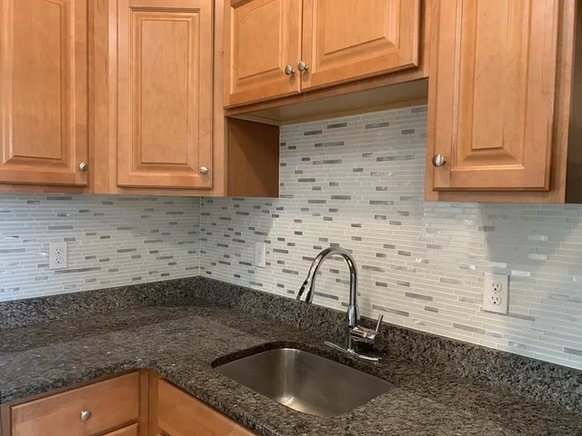 a kitchen with granite countertop a sink and a stove