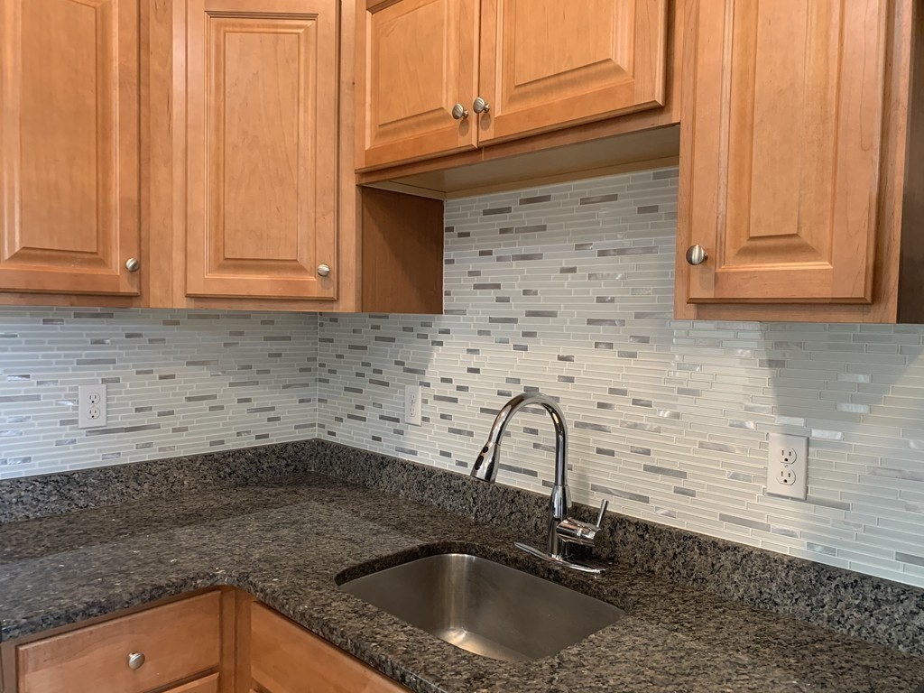 107 Chelsea Street, Unit 3 Boston, MA 02128 - Photo 10 of 15 a kitchen with granite countertop a sink and a stove