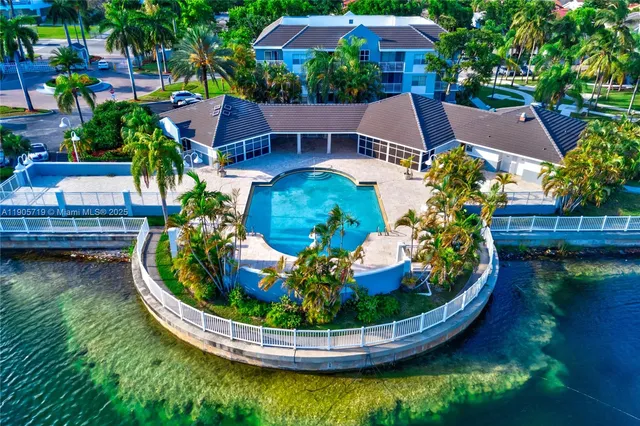 an aerial view of a house with swimming pool and outdoor seating