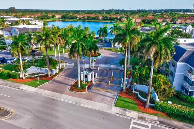 a view of a small yard in front of a house with large tree and plants