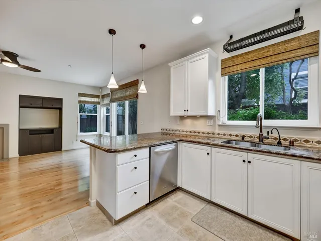 a kitchen with granite countertop a sink and cabinets