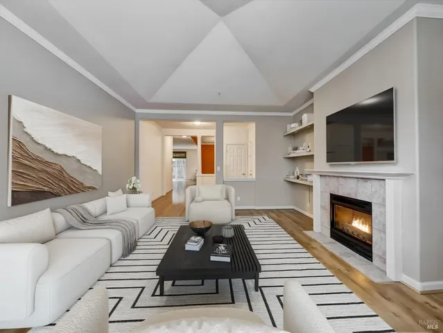 a living room with furniture a flat screen tv and a fireplace