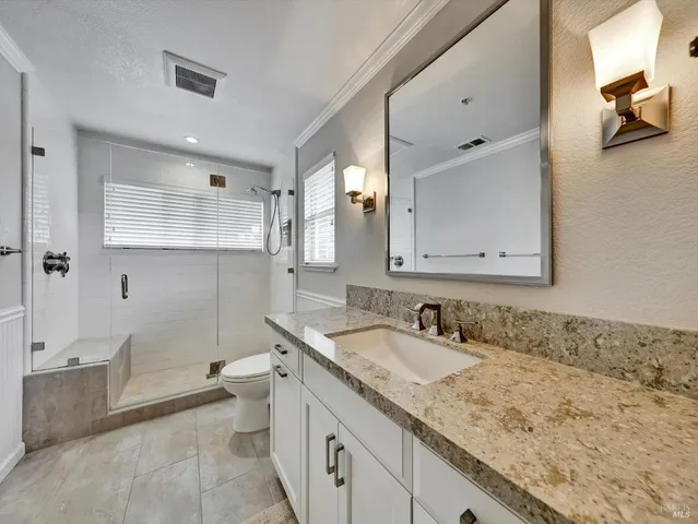 a bathroom with a granite countertop sink mirror and a bathtub