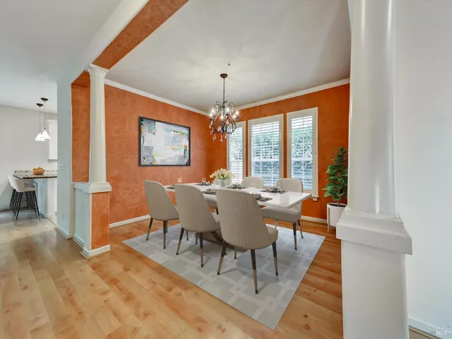 a dining room with furniture a chandelier and wooden floor