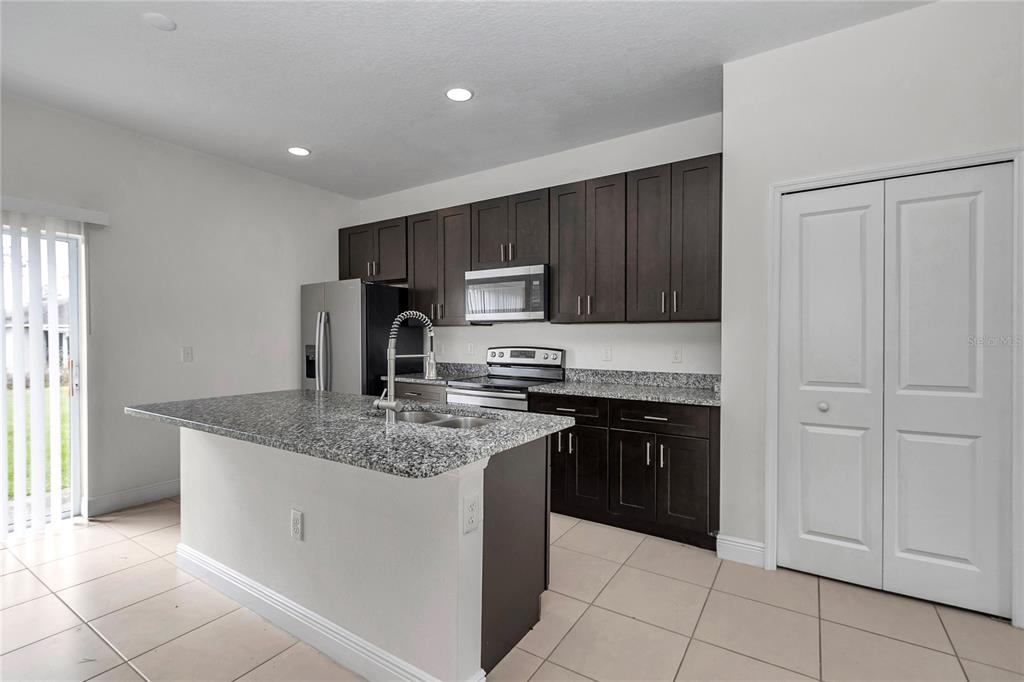 3650 Southwest 128th Place Ocala, FL 34473 - Photo 12 of 40 a kitchen with stainless steel appliances granite countertop a stove a sink and a refrigerator