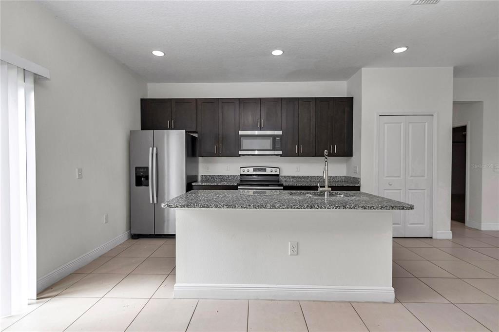 3650 Southwest 128th Place Ocala, FL 34473 - Photo 13 of 40 a kitchen with stainless steel appliances granite countertop a refrigerator stove a sink and a oven